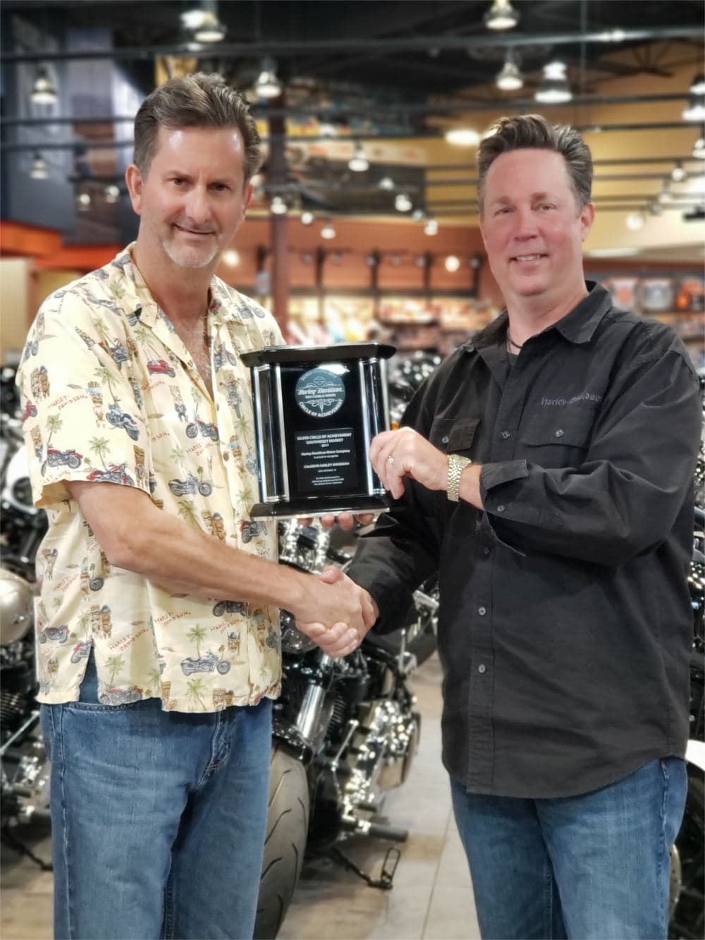 A staff-member receives the Harley-Davidson Bar and Shield award plaque.